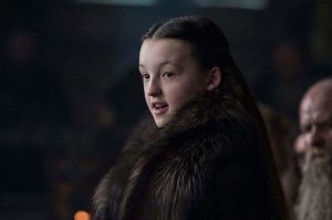 Cropped image of Bella Ramsey on set wearing a fur coat