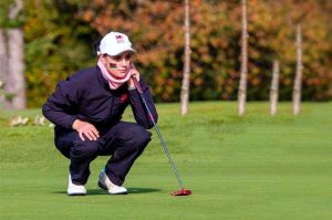 Darcy Harry crouched on a golf course